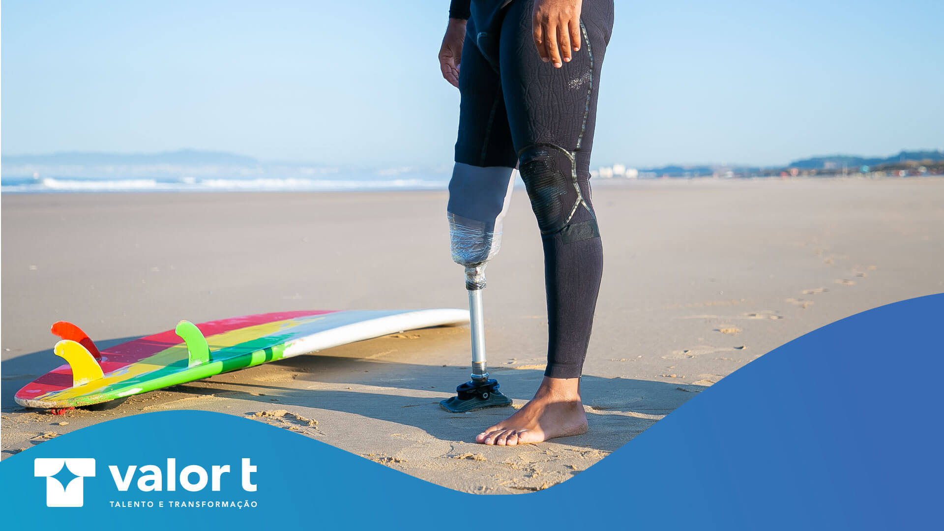 Homem com uma prótese na perna equipado para ir surfar ao seu lado esquerdo tem uma prancha de surf